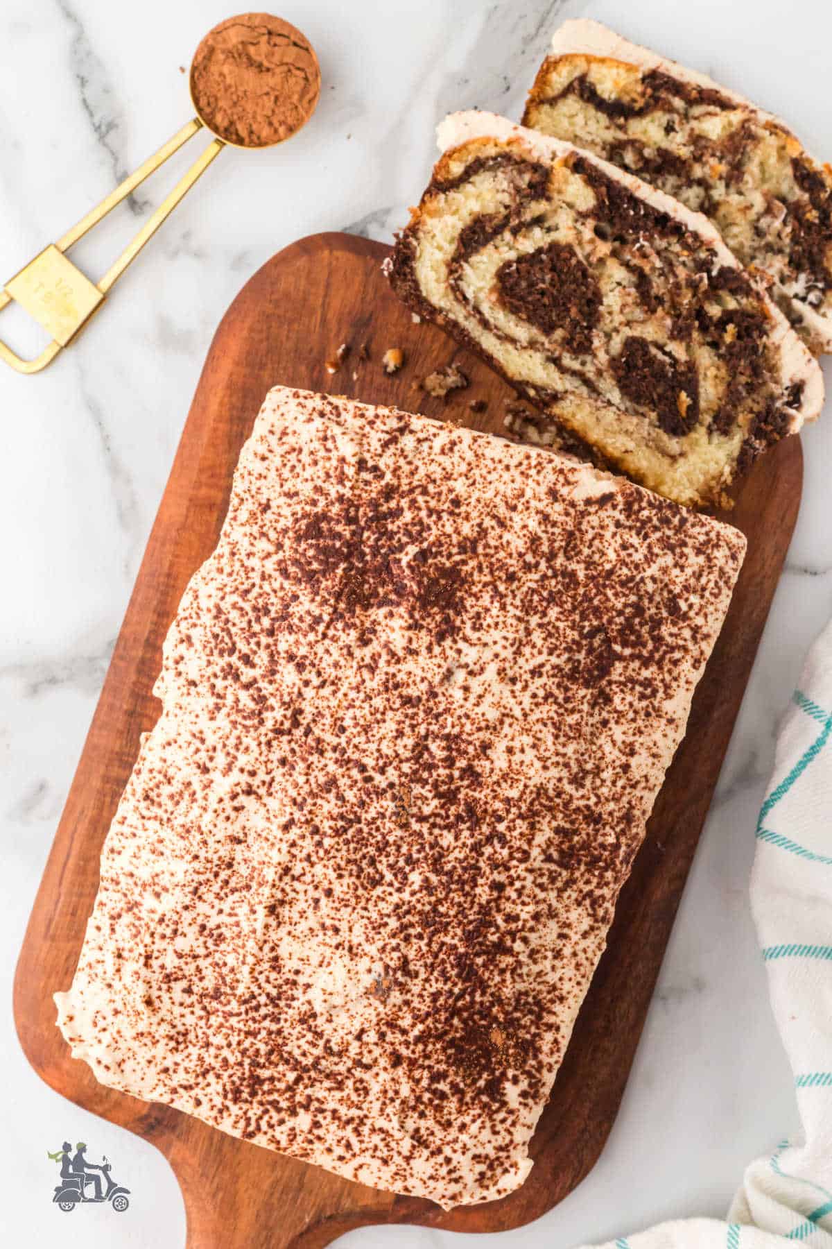 Tiramisu Swirl Quick Bread on a cutting board frosted with mascarpone whipped topping. 