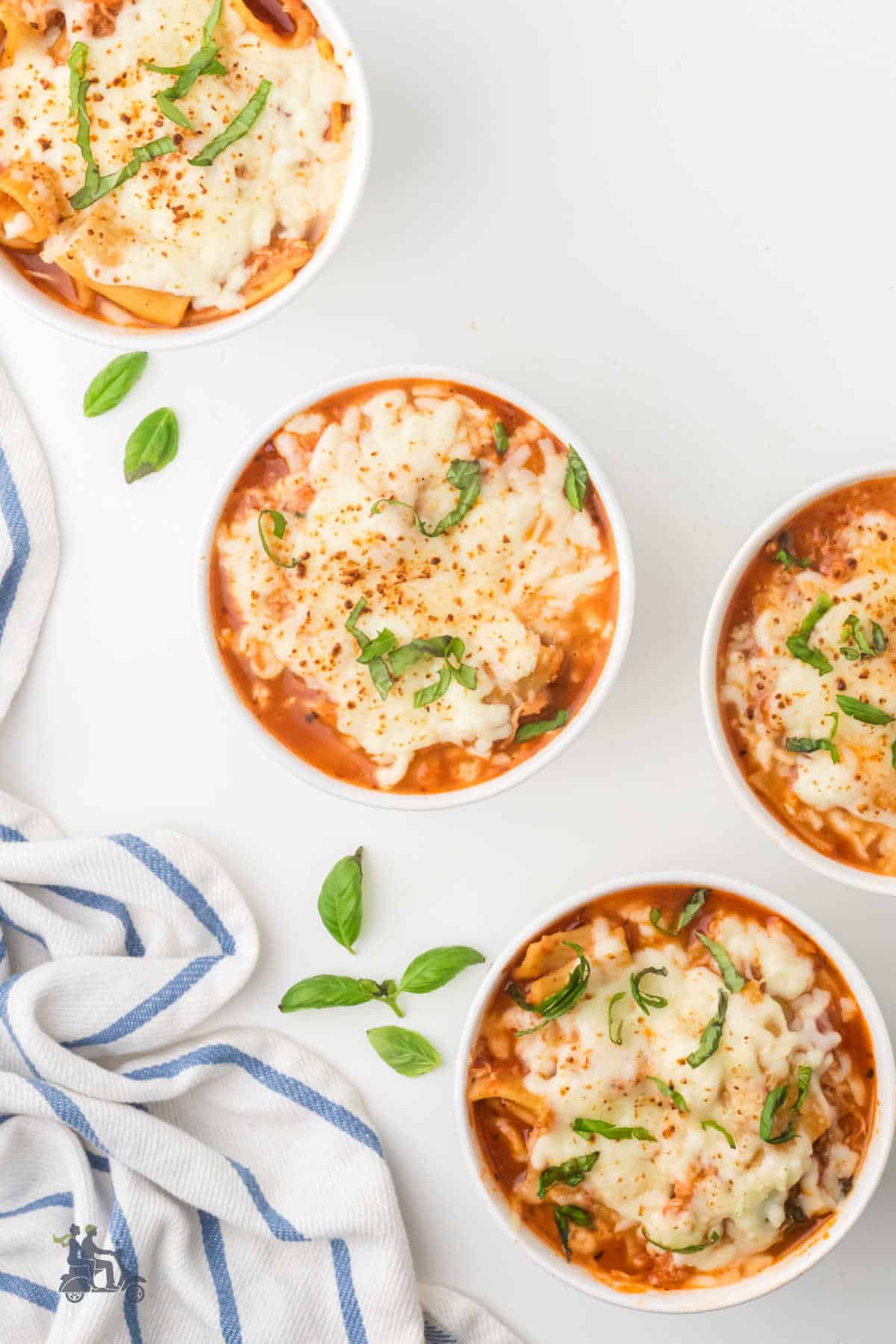 Bubbly melted mozzarella and Parmesan on Chicken soup with rigatoni pasta and basil.