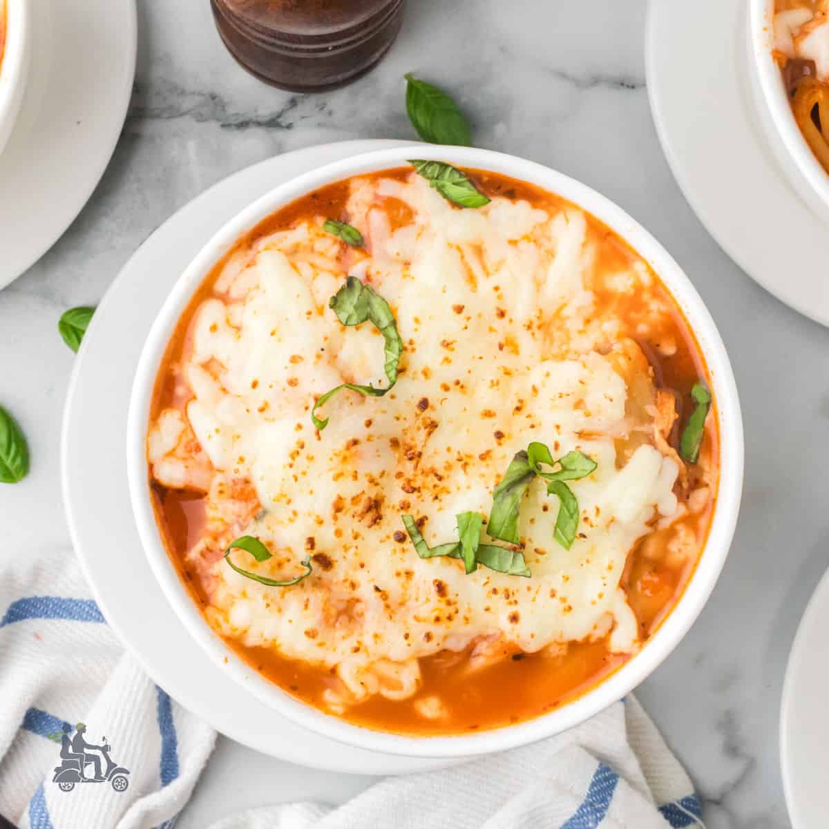 Close-up of bubbly melted mozzarella and parmesan on Chicken Parmesan Soup.