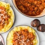 Italian pork shoulder ragù recipe shown in a Dutch oven and served with pappardelle on plates.