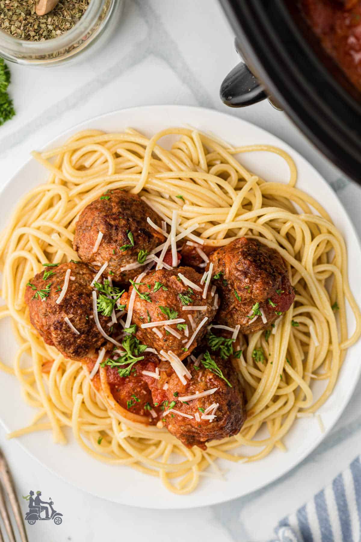 Saucy Slow cooker meatballs served with spaghetti and rich homemade tomato sauce.