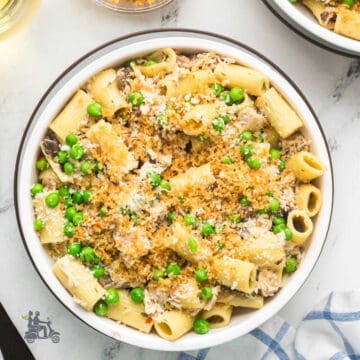 Chicken tetrazzini from scratch made with rotisserie chicken and frozen peas, served in a white bowl.