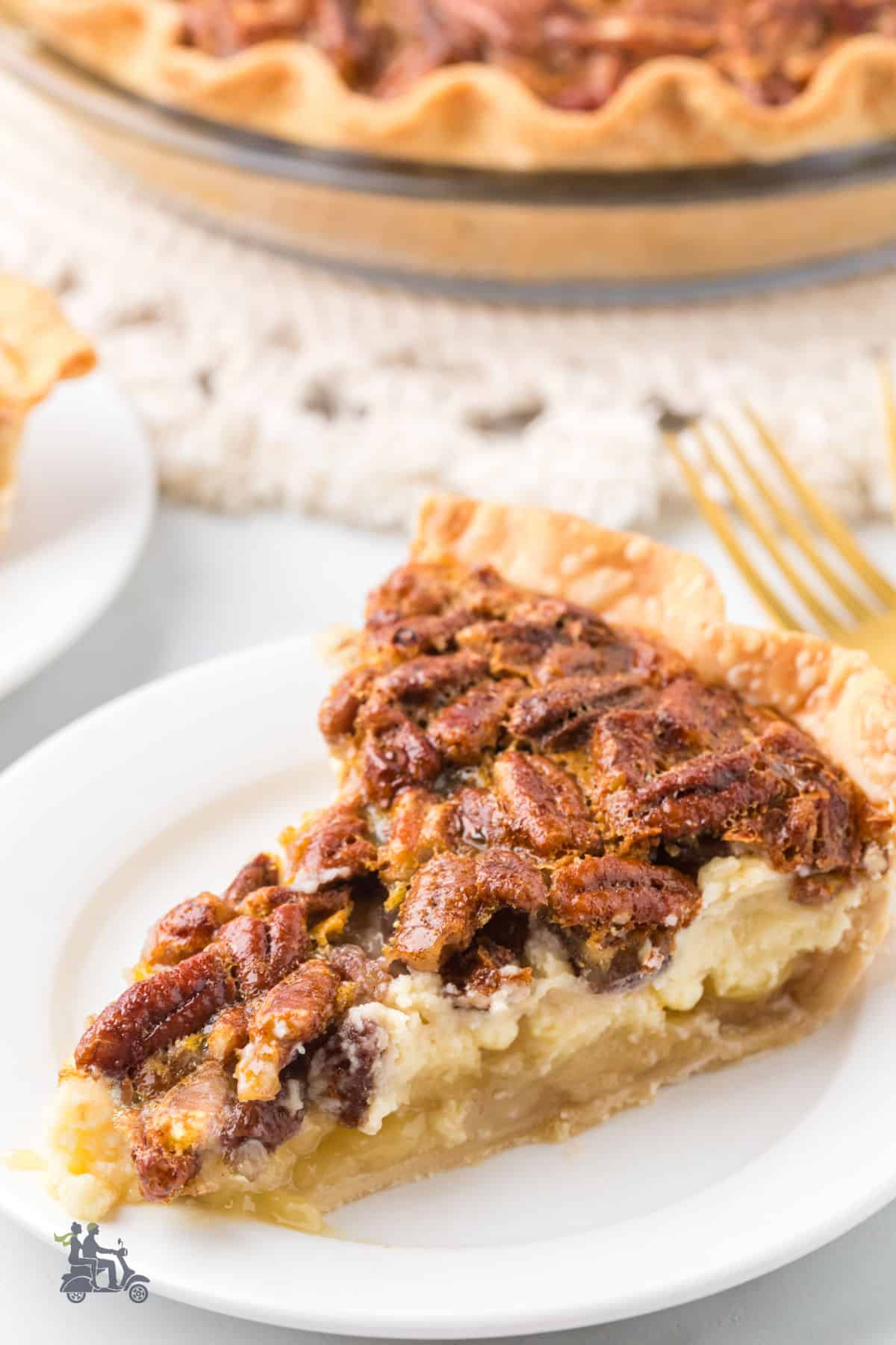 A slice of homemade pecan layered cheesecake pie on a white plate.