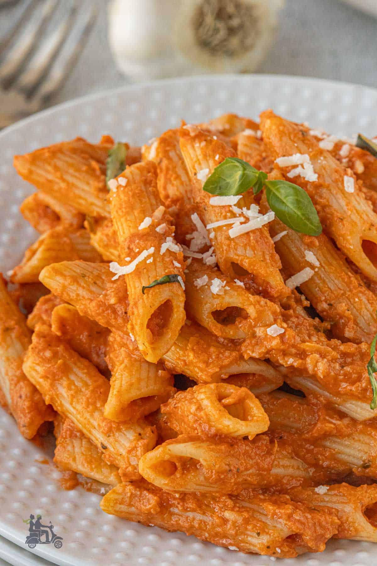 Close-up of a dinner serving of creamy penne pasta with rich tomato vodka sauce.