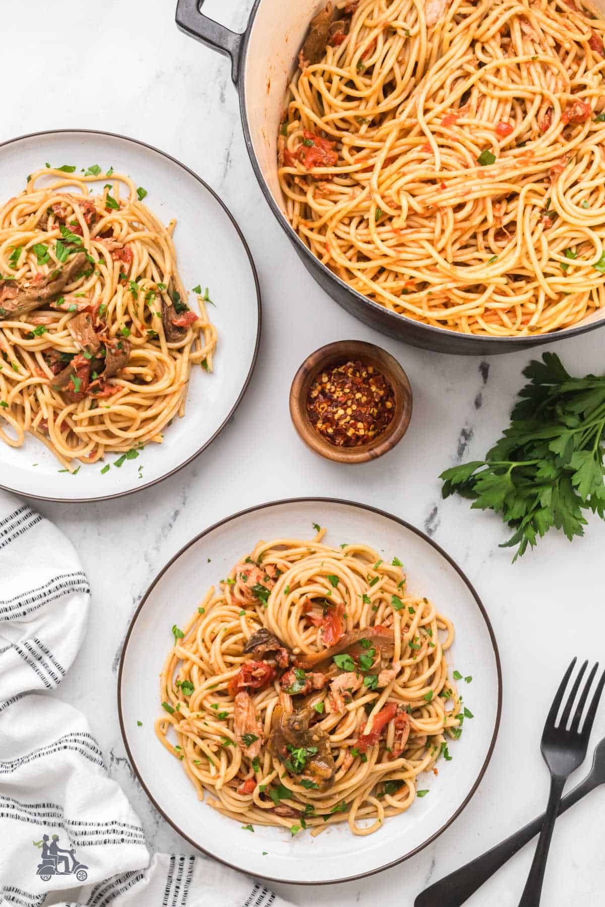 Overhead view of Roman-style tuna pasta garnished with fresh Italian parsley.