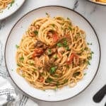 Roman-Style tuna spaghetti with tomato sauce, porcini mushrooms, and chopped parsley.