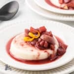 Close-up of creamy buttermilk panna cotta topped with ruby port fruit sauce.