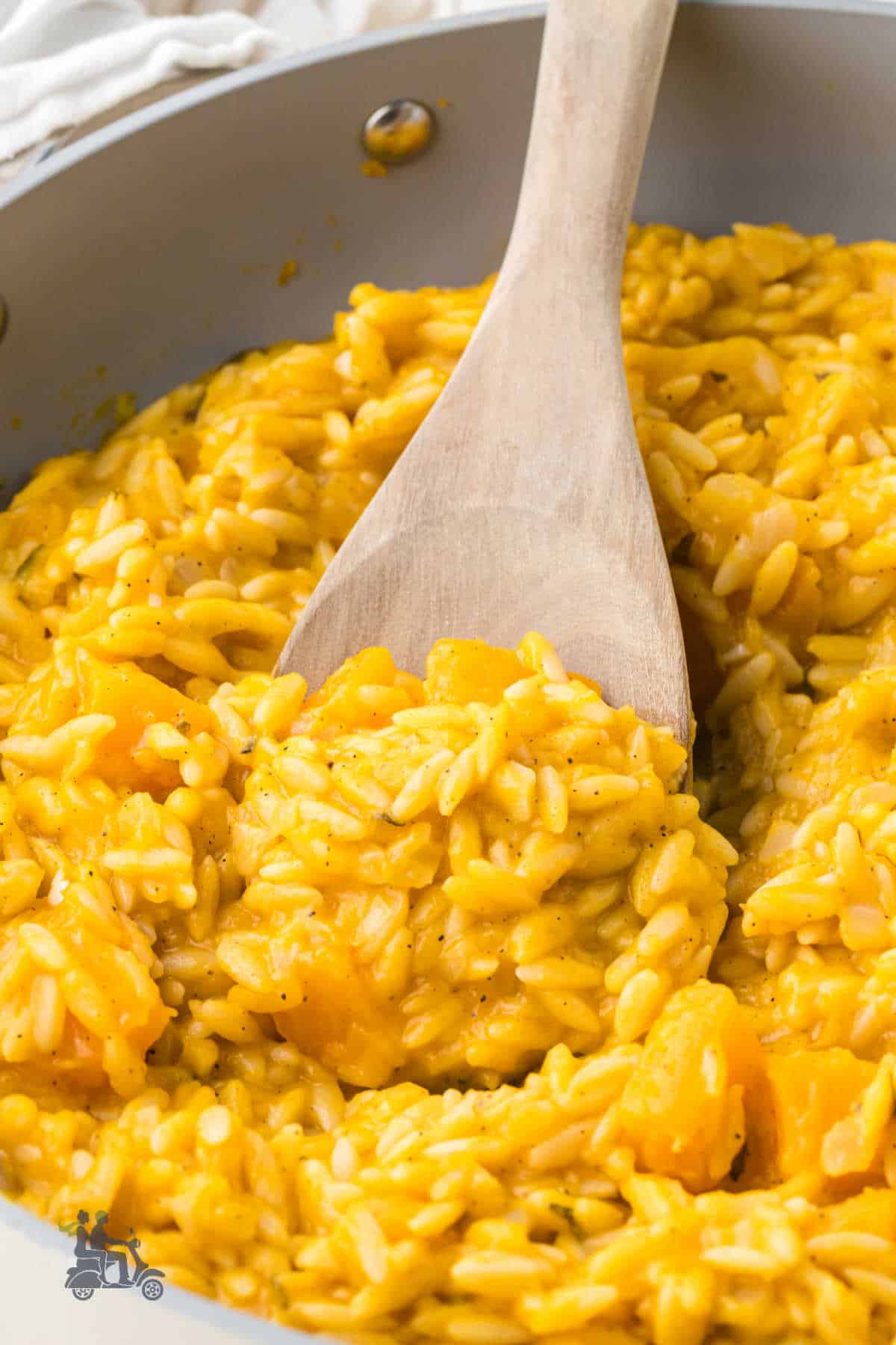 Spoonful of creamy butternut squash orzotto with tender pieces of butternut squash visible. 