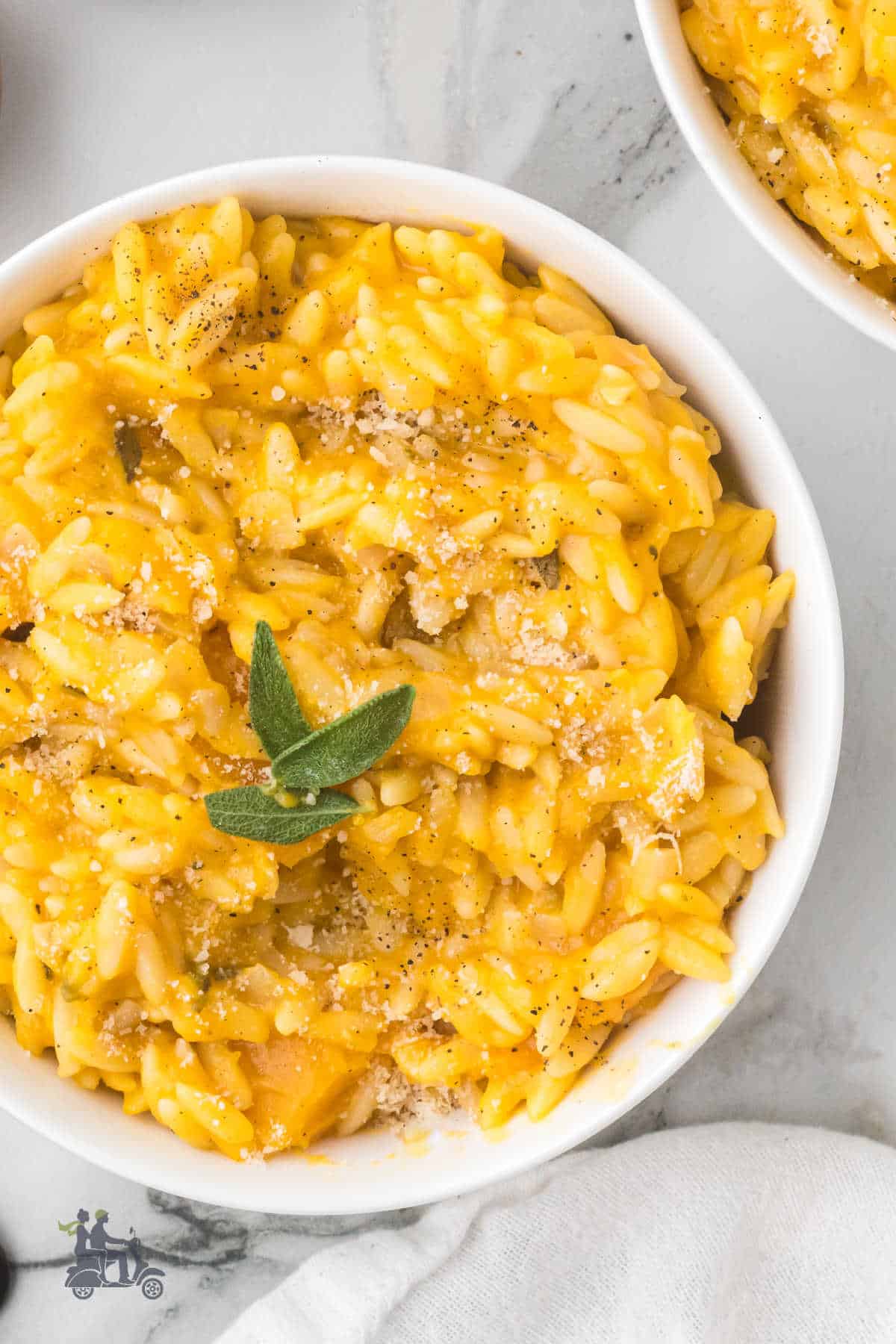 Close-up of orzo pasta coated in creamy golden butternut squash sauce. 